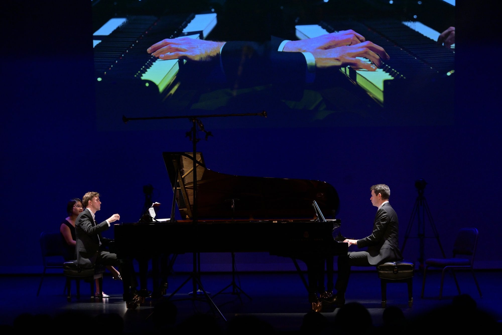 Both pianists at work, with the keyboards projected on the screen above
