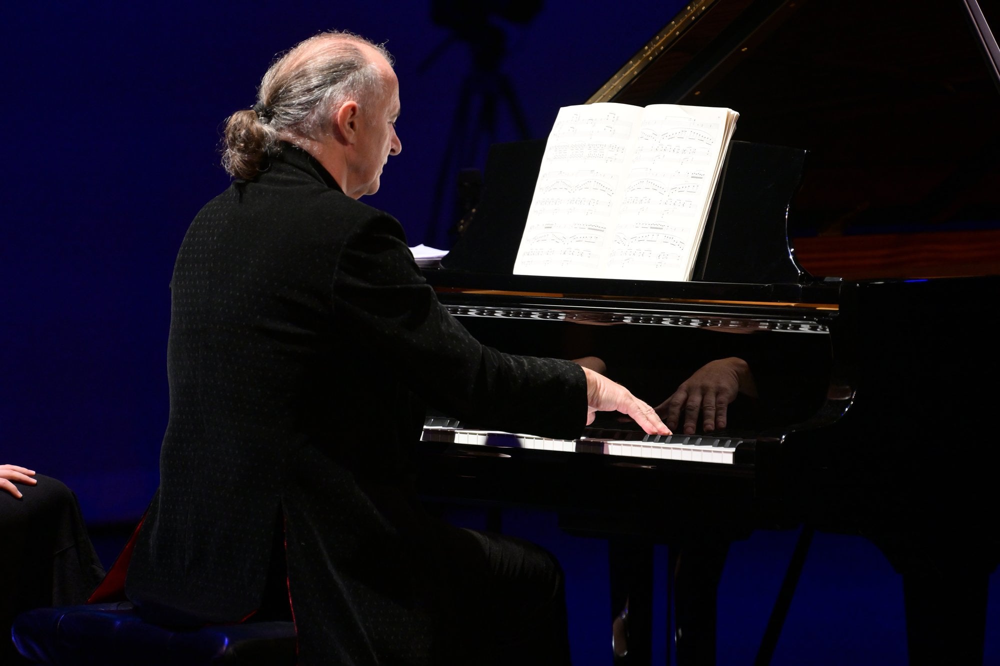 A pianist reading from the score at the piano
